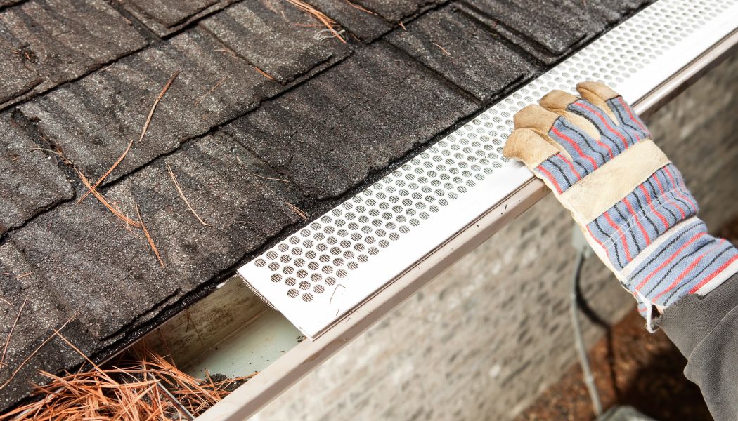 A person installing gutter guards.